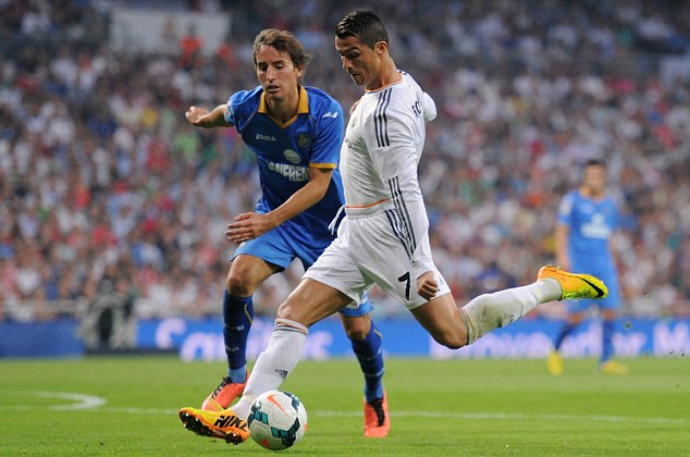 MADRID, SPAIN - SEPTEMBER 22: Cristiano Ronaldo (R) shoots past Pedro Mosquera Getafe during the La Liga match between Real Madrid and Getafe at the Bernabeu on September 22, 2013 in Madrid, Spain. (Photo by Denis Doyle/Getty Images)