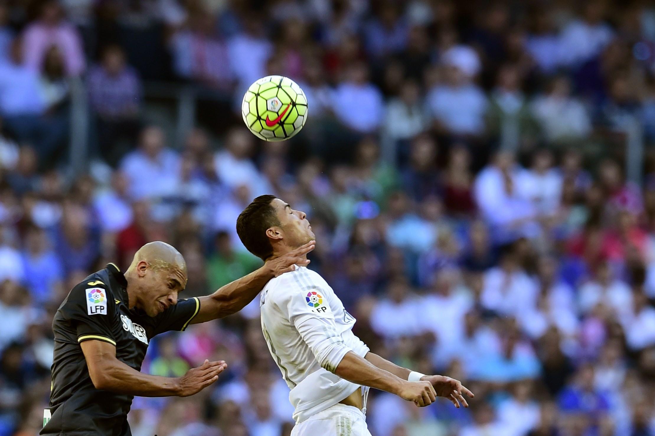 Real Madrid's Portuguese forward Cristiano Ronaldo (R) vies with Granada's Brazilian defender Doria during the Spanish league football match Real Madrid CF vs Granada FC at the Santiago Bernabeu stadium in Madrid on Spetember 19, 2015. AFP PHOTO/ JAVIER SORIANO (Photo credit should read JAVIER SORIANO/AFP/Getty Images)